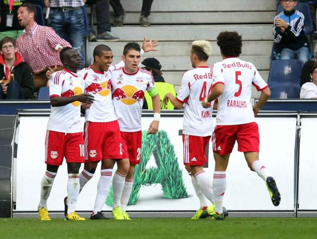 Fußballspieler von Red Bull Salzburg feiern auf dem Spielfeld.