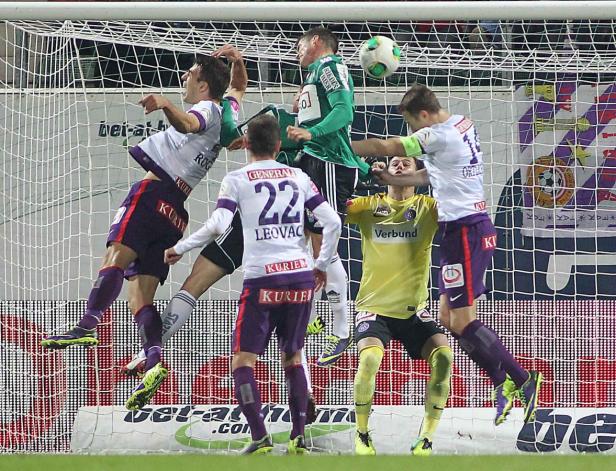 Fußballspieler kämpfen um den Ball vor dem Tor.