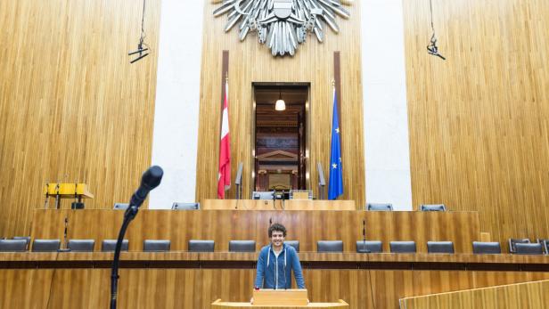 Ein junger Mann steht am Rednerpult im österreichischen Parlament.