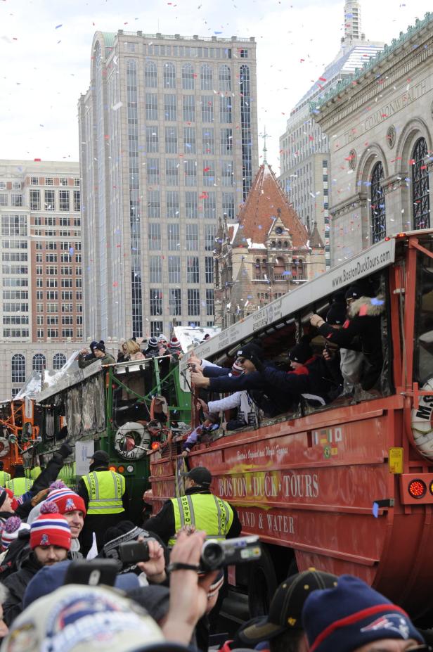 Eine Parade der Boston Duck Tours zieht durch die Stadt, begleitet von Konfetti.