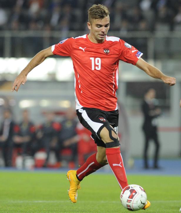 Ein österreichischer Fußballspieler mit der Nummer 19 am Ball.