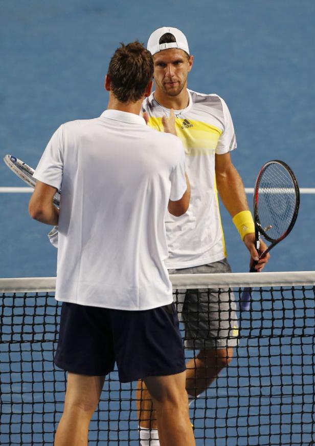 Zwei Tennisspieler schütteln sich nach einem Match am Netz die Hände.