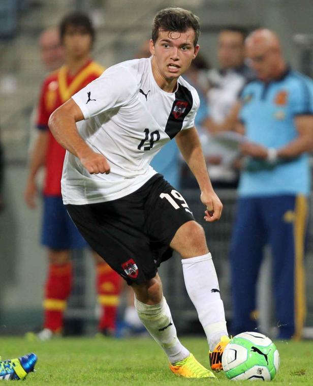 Ein österreichischer Fußballspieler mit der Nummer 19 am Ball.
