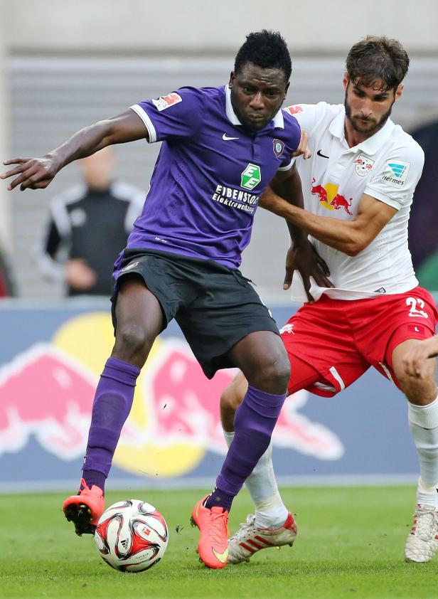 Zwei Fußballspieler kämpfen um den Ball auf dem Spielfeld.