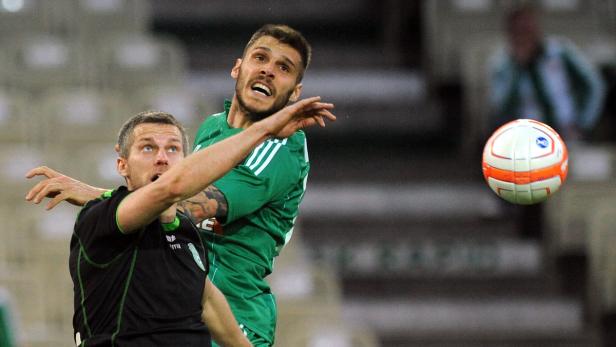 Zwei Fußballspieler kämpfen um einen Ball in der Luft.