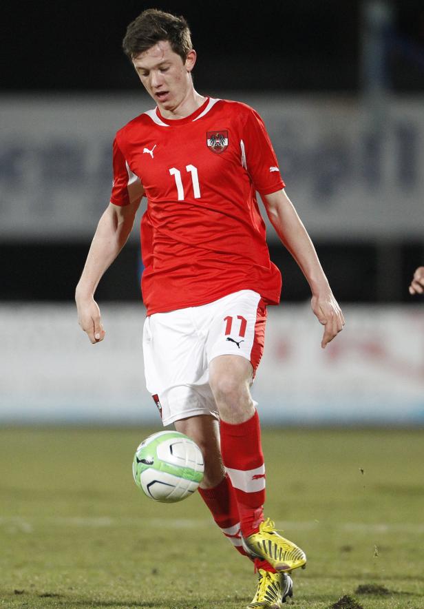 Ein österreichischer Fußballspieler mit der Nummer 11 am Ball.
