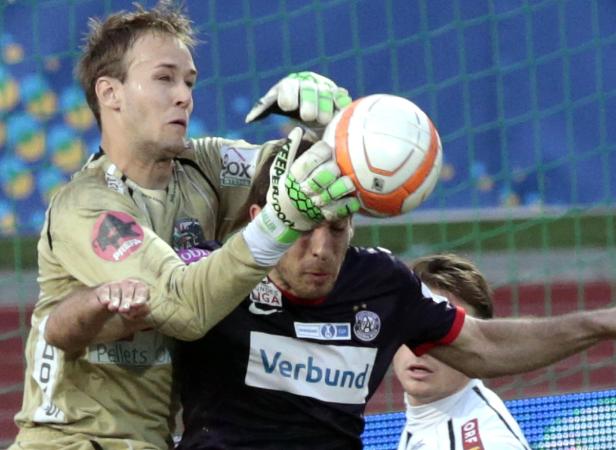 Zwei Torhüter kämpfen um den Ball vor einem Fußballtor.