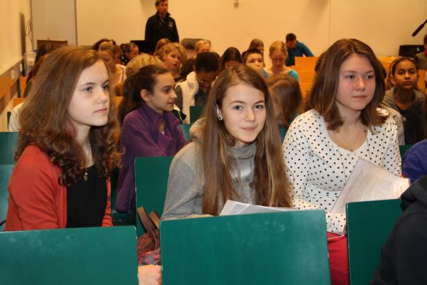 Eine Gruppe von Schülerinnen sitzt in einem Hörsaal während einer Vorlesung.