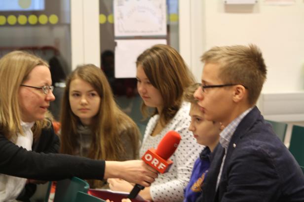Eine Reporterin des ORF interviewt eine Gruppe von Jugendlichen.