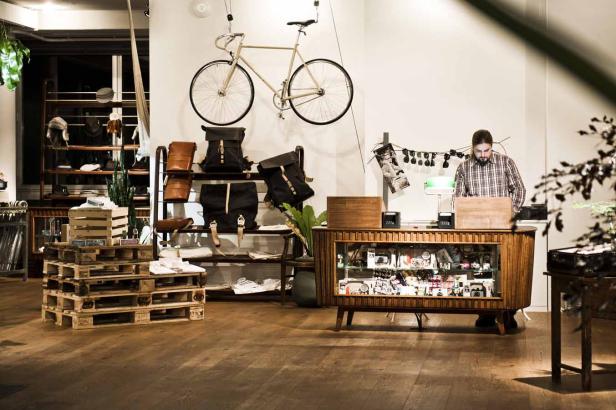 Ein Mann steht in einem Bekleidungsgeschäft mit Fahrrädern und Rucksäcken.