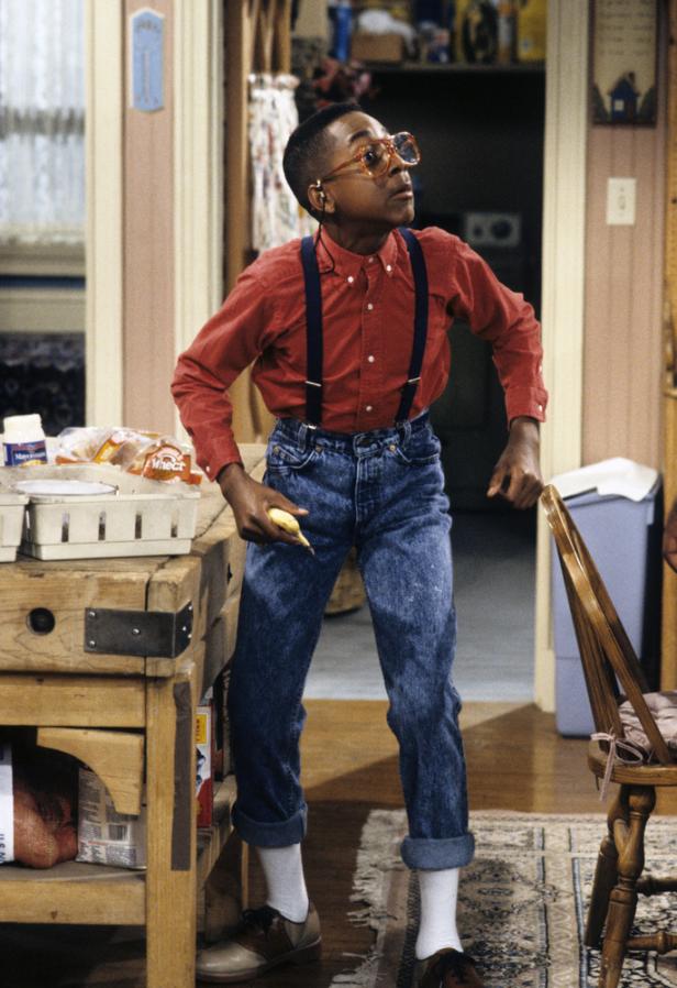 Steve Urkel steht in der Küche und hält eine Banane in der Hand.