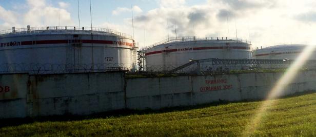 Mehrere Tanks des Ölkonzerns Lukoil hinter einer Betonmauer mit Stacheldraht.