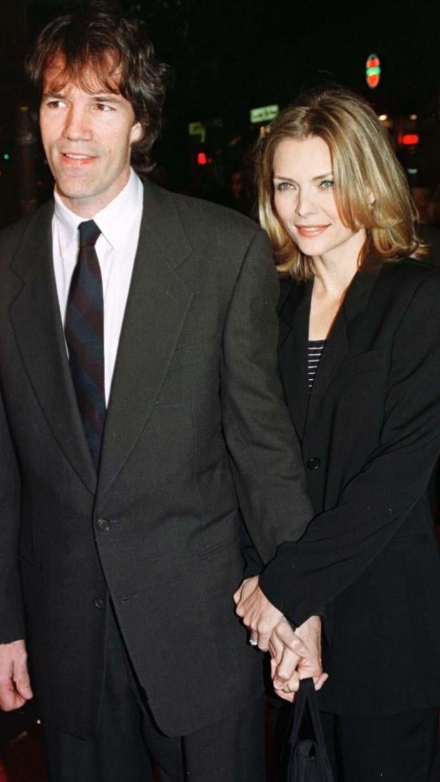 Timothy Hutton und Michelle Pfeiffer halten Händchen auf dem roten Teppich.