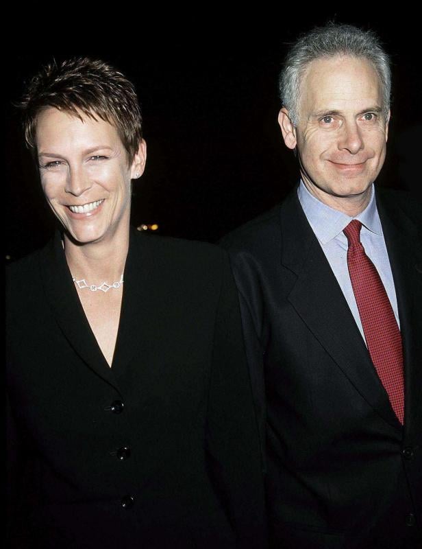 Jamie Lee Curtis und Christopher Guest posieren lächelnd nebeneinander.