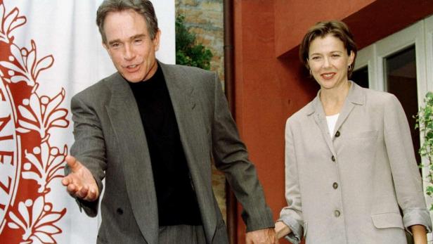 Warren Beatty und Annette Bening halten Händchen.