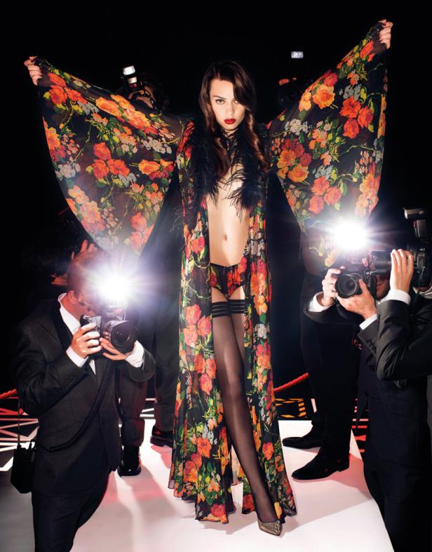 Eine Frau in Unterwäsche und einem floralen Kimono posiert für Paparazzi.