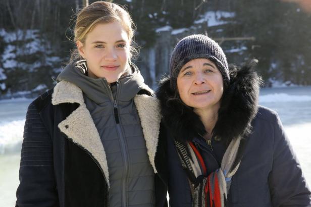 Zwei Frauen stehen im Winter vor einer verschneiten Landschaft.