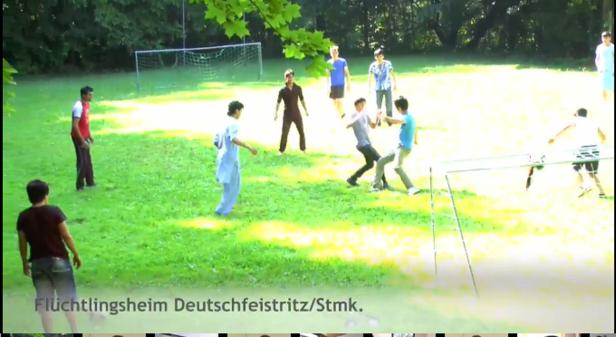 Eine Gruppe junger Männer spielt Fußball auf einer grünen Wiese.
