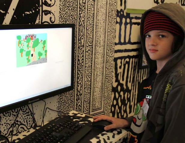 Ein Jugendlicher mit Kapuze sitzt vor einem Computer und spielt ein Computerspiel.