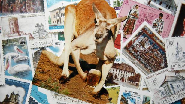 Ein Känguru hält ein Bierglas vor einem Hintergrund aus rumänischen Briefmarken.
