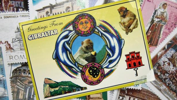 Eine Postkarte aus Gibraltar mit einem Affen, Delfinen, Sonne und Mond.