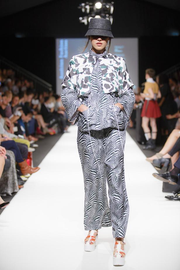 Eine Frau präsentiert ein Outfit mit Zebra- und Camouflagemuster auf einem Laufsteg.