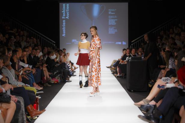 Zwei Models präsentieren Mode auf dem Laufsteg während einer Veranstaltung der Austrian Fashion Auction.