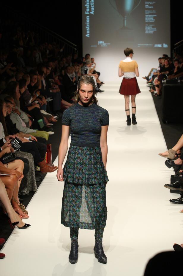 Eine Frau präsentiert ein Outfit auf einer Modenschau.