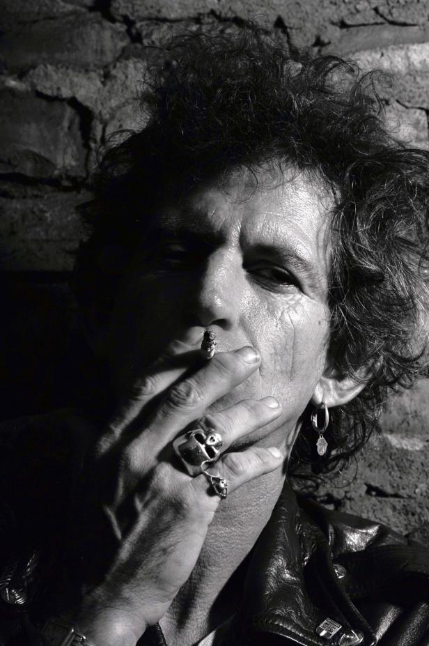 Schwarzweißporträt von Keith Richards, der eine Zigarette raucht.