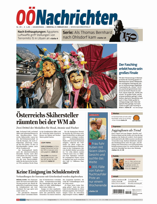 Zwei maskierte Personen in traditionellen Faschingskostümen während eines Umzugs.