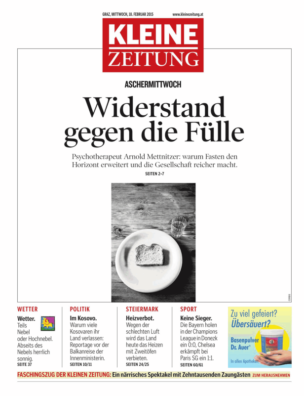 Ein Teller mit einer Scheibe Brot und ein Glas Wasser auf einem Holztisch.