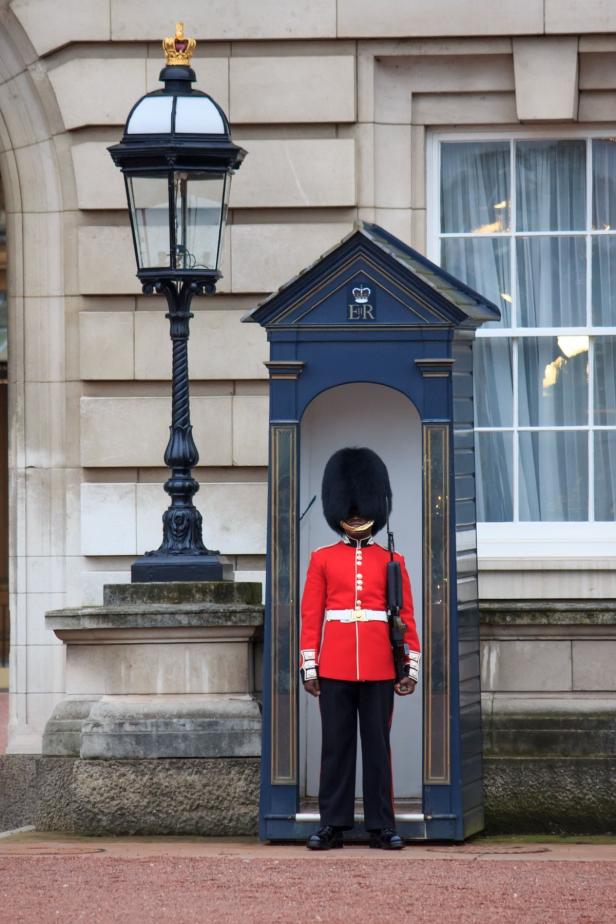 Ein Gardesoldat steht in seiner Wachkabine vor dem Buckingham Palace.