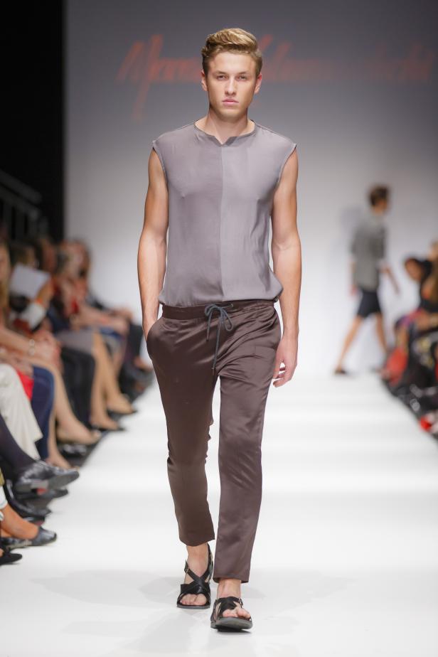 Ein Mann präsentiert ein Outfit auf einem Laufsteg.