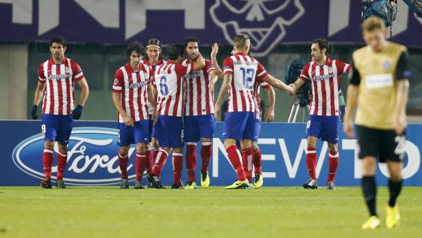 Fußballspieler von Atlético Madrid feiern auf dem Spielfeld.