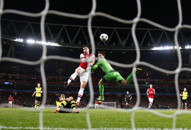 Ein Fußballspieler köpft den Ball vor dem Torwart während eines Fußballspiels.