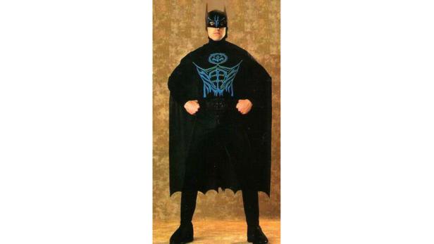 Eine Person in einem Batman-Kostüm mit einem ungewöhnlichen Logo auf der Brust.