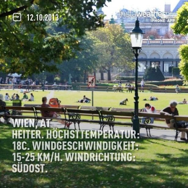 An einem sonnigen Tag sitzen Menschen auf Bänken und entspannen im Park in Wien.
