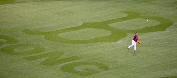 Ein Baseballspieler wirft einen Ball auf einem Feld mit dem Boston Red Sox Logo.