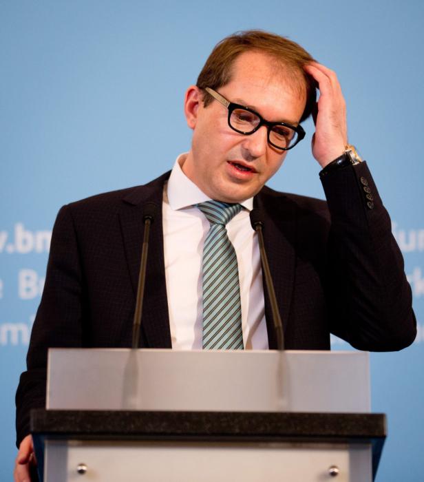 Ein Mann mit Brille spricht am Rednerpult und fährt sich durch die Haare.