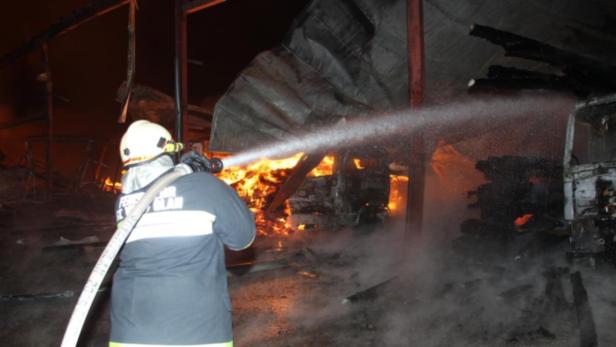 Ein Feuerwehrmann löscht einen Brand in einem zerstörten Gebäude.