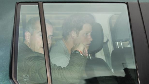 Prinz Harry sitzt mit einer Begleitperson im Fond eines Autos.