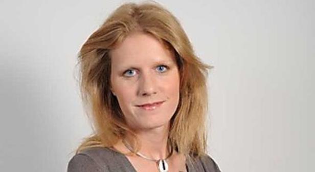 Porträt einer Frau mit blonden Haaren und einem silbernen Halsband.