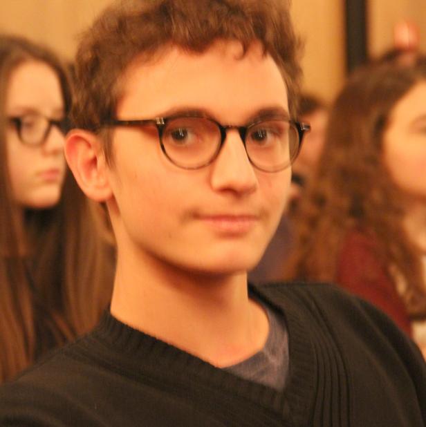 Ein junger Mann mit Brille schaut in die Kamera.