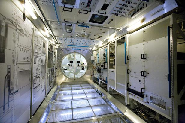 Das Innere eines Moduls der Internationalen Raumstation mit Geräten und einem Fenster.