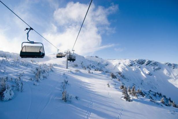 Hochkar im Hochwinter. (c: hockar bergbahnen - zach jan qparks) Eine Gondelbahn fährt über eine verschneite Berglandschaft.