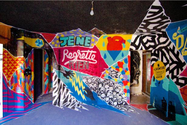 Ein Raum ist mit Graffiti und dem Schriftzug „Je ne regrette rien“ gestaltet.