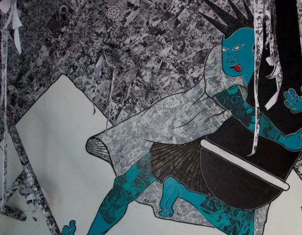 Ein blauhäutiger Charakter mit Irokesenschnitt und Tätowierungen ist auf einer Wand dargestellt.