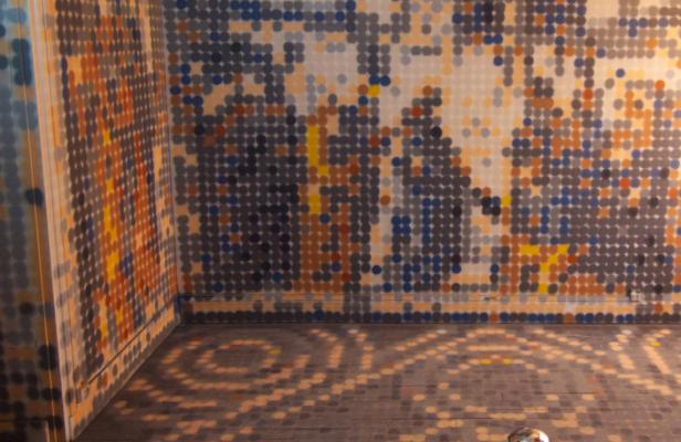 Ein Raum, dessen Wände und Boden mit einem Punktmuster in verschiedenen Farben bedeckt sind.