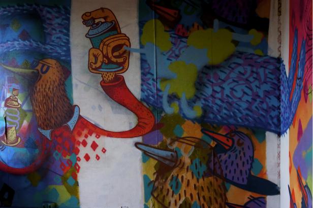 Ein Wandgemälde mit stilisierten Vögeln und Graffiti-Elementen.