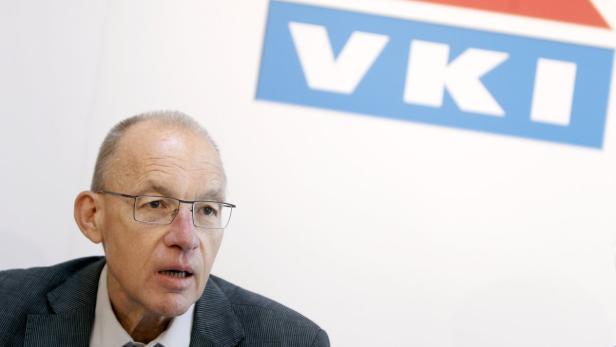 Ein Mann mit Brille spricht vor einem VKI-Logo.